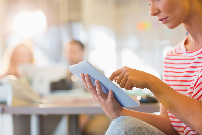 Patient looking at the patient resources Three Rivers Orthopedics have available using her tablet